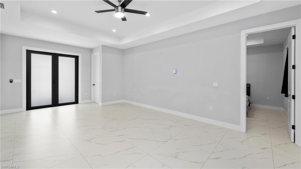 4571 22nd Street Northeast Naples, FL 34120 - Photo 7 of 47 Unfurnished room with a tray ceiling, light marble finish floors, a ceiling fan, and recessed lighting
