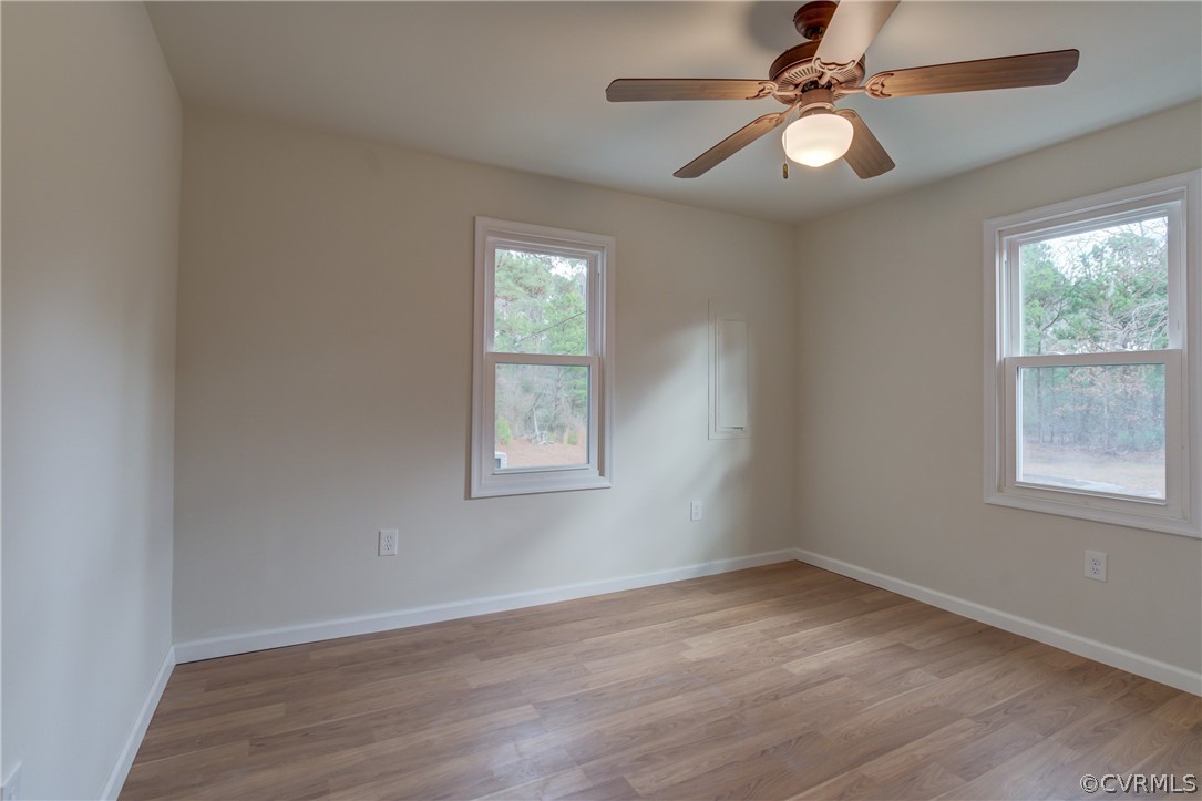 4462 Windmill Point Road White Stone, VA 22578 - Photo 14 of 48 an empty room with wooden floor fan and windows