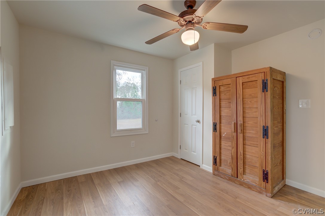 4462 Windmill Point Road White Stone, VA 22578 - Photo 15 of 48 an empty room with wooden floor fan and windows