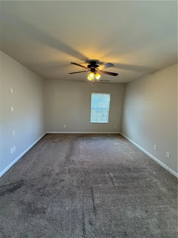 an empty room with a ceiling fan and window