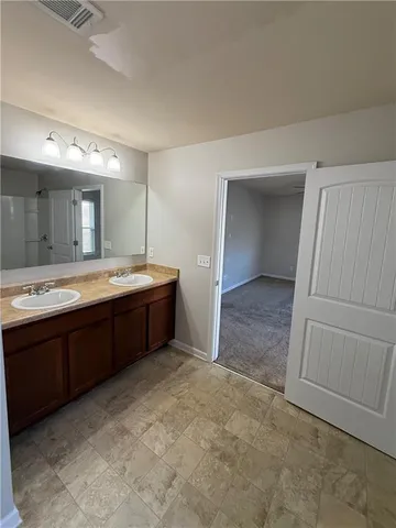 a spacious bathroom with a double vanity sink and mirror