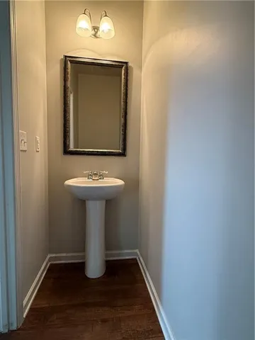 a view of a hallway with wooden floor and white cabinet