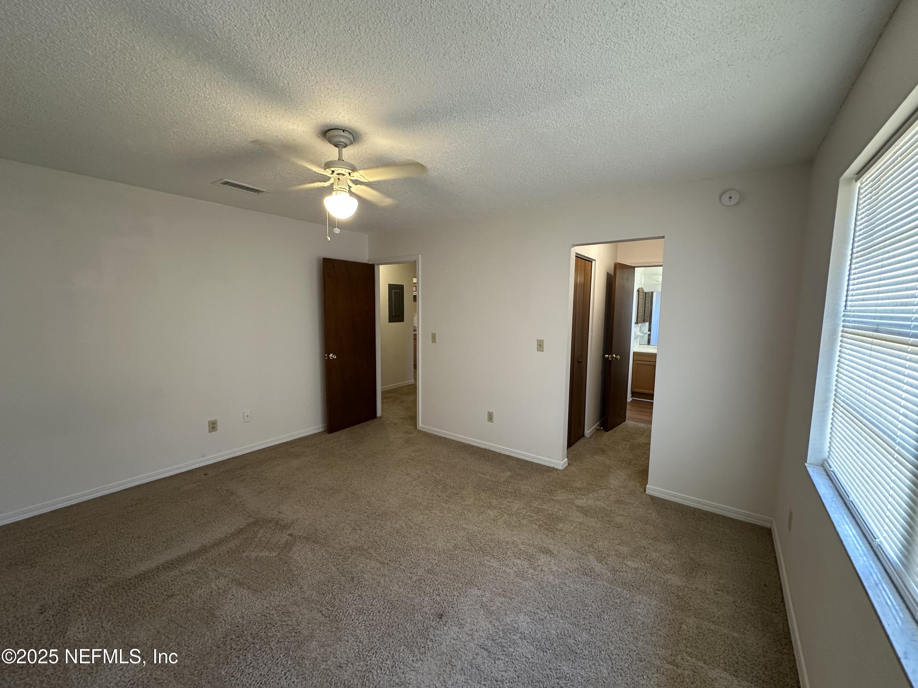 2934 Shelby Drive Orange Park, FL 32073 - Photo 4 of 6 an empty room with a ceiling fan and a window