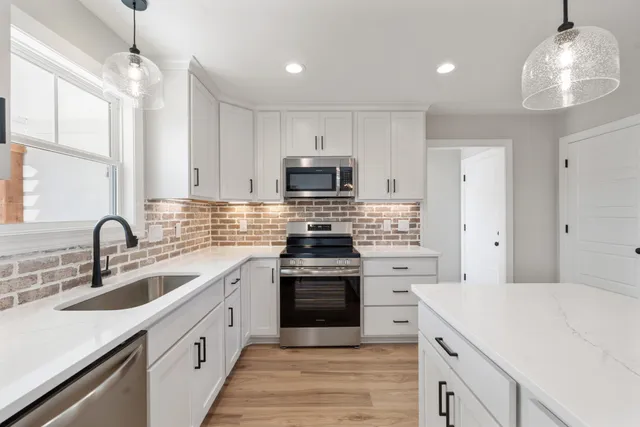 a kitchen with cabinets a sink and stainless steel appliances
