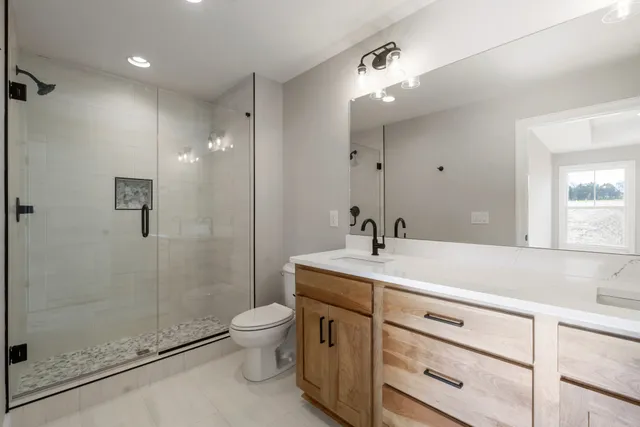 a bathroom with a sink a toilet and shower