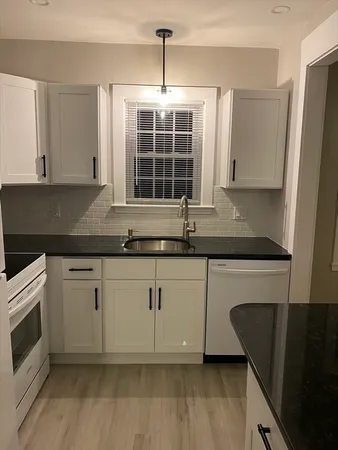 a kitchen with granite countertop a sink and a stove