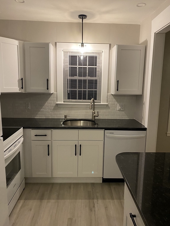 91 Main, Unit 2W Easton, MA 02356 - Photo 4 of 8 a kitchen with granite countertop a sink and a stove