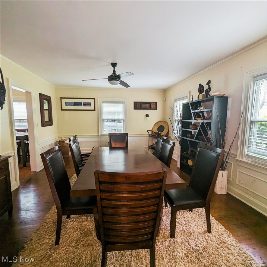 557 Cambridge Road Coshocton, OH 43812 - Photo 11 of 20 Dining room with molding, dark wood-style floors and wainscoted walls.