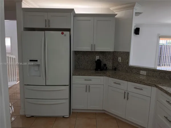 a kitchen with white cabinets and white appliances