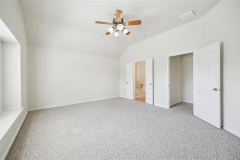 a view of a room with a ceiling fan and a window