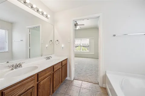 a spacious bathroom with a bathtub sink and mirror