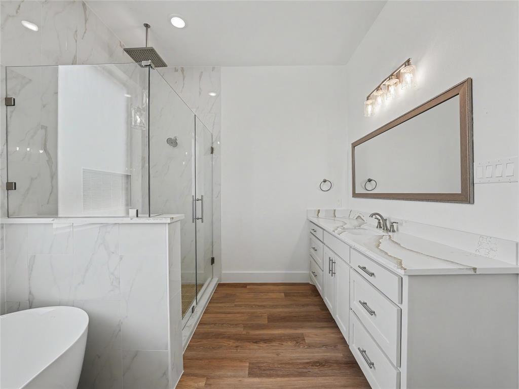 328 Slimp Bluff Azle, TX 76020 - Photo 18 of 30 Modern bathroom featuring a glass-enclosed shower with rain showerhead, freestanding soaking tub, and double vanity with dual sinks