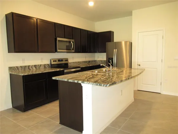 a kitchen with stainless steel appliances granite countertop a stove and a refrigerator