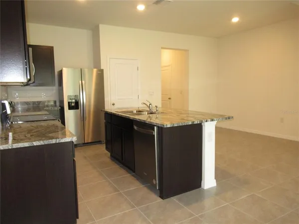 a kitchen with stainless steel appliances granite countertop a sink and a refrigerator