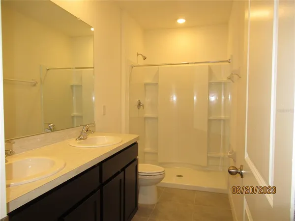 a bathroom with a granite countertop sink a toilet and shower