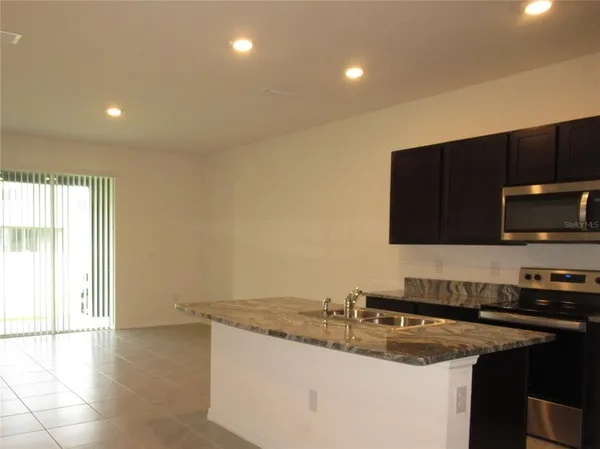 a kitchen with a sink and a stove top oven with wooden floor