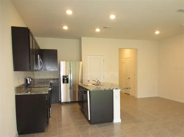 a kitchen with stainless steel appliances granite countertop a sink a stove and a refrigerator