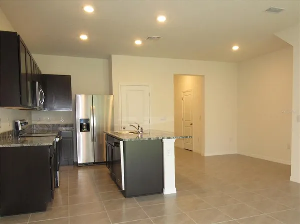 a kitchen with refrigerator and cabinets
