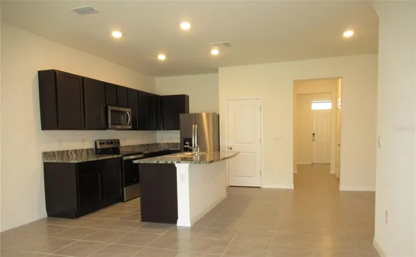 a kitchen with stainless steel appliances granite countertop a refrigerator and a stove