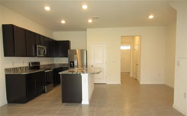 a kitchen with stainless steel appliances granite countertop a refrigerator a stove top oven a sink and dishwasher