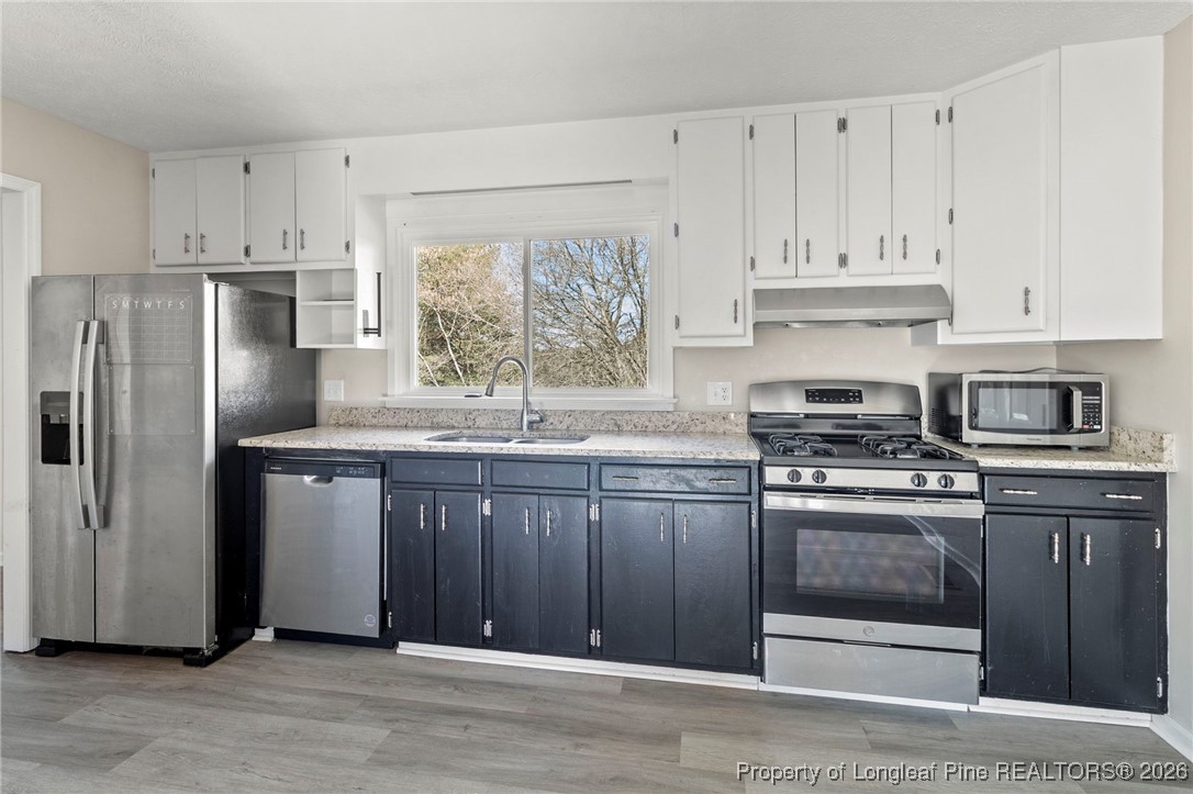 5196 Remington Road Fayetteville, NC 28311 - Photo 11 of 34 a kitchen with stainless steel appliances granite countertop a stove a refrigerator and a sink with cabinets