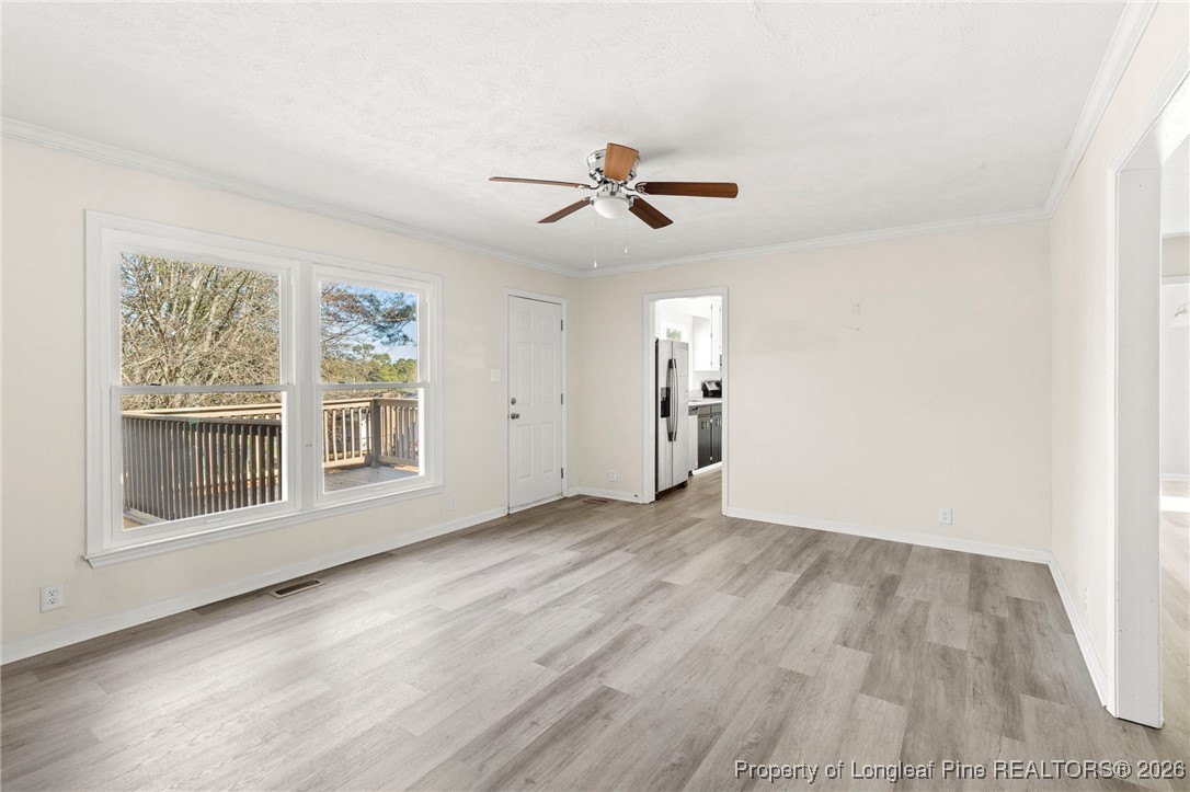 5196 Remington Road Fayetteville, NC 28311 - Photo 15 of 34 an empty room with wooden floor ceiling fan and windows