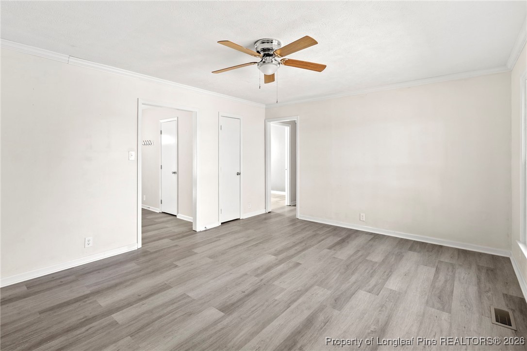 5196 Remington Road Fayetteville, NC 28311 - Photo 16 of 34 an empty room with wooden floor and ceiling fan