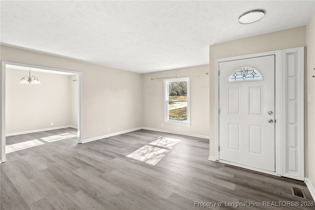 5196 Remington Road Fayetteville, NC 28311 - Photo 7 of 34 an empty room with wooden floor and windows
