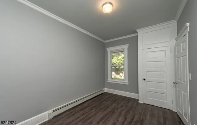 an empty room with wooden floor and window