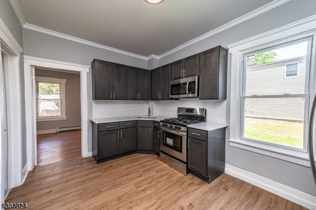 a kitchen with granite countertop wooden floors and stainless steel appliances
