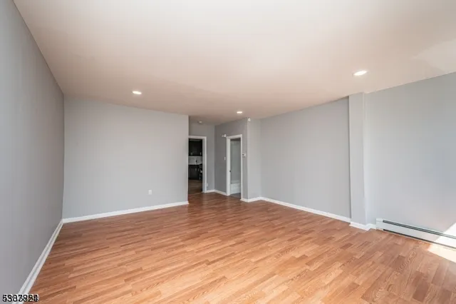 a view of an empty room with wooden floor