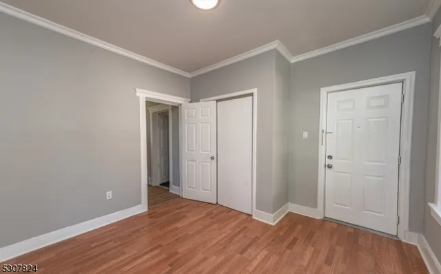 a view of an empty room with wooden floor
