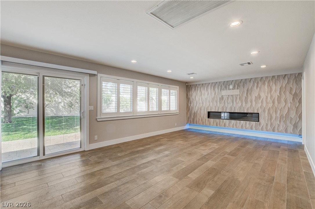 4207 Ridgecrest Drive Las Vegas, NV 89121 - Photo 10 of 27 Family room off kitchen with a premium fireplace, recessed lighting, and an accent wall