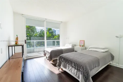 a bedroom with two beds and a large window