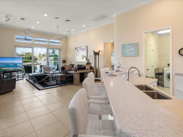 a large kitchen with stainless steel appliances a large counter top a stove a sink a couch and a window