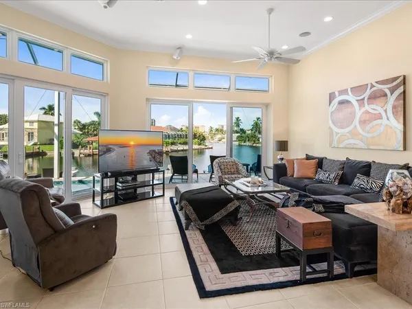 a living room with furniture fireplace and large windows