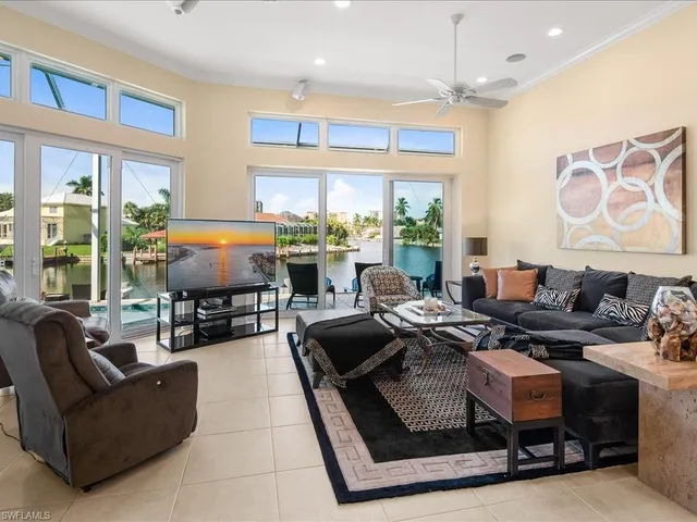 a living room with furniture fireplace and large windows