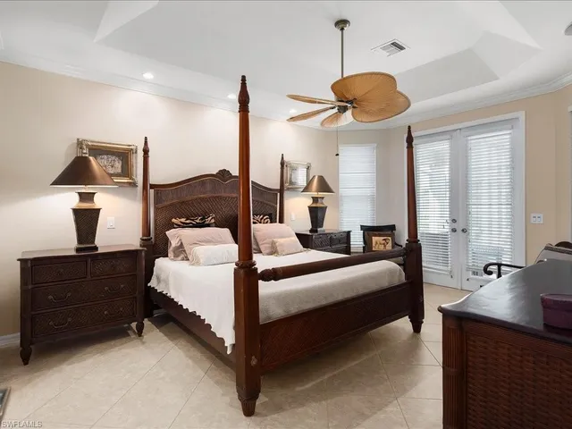 a bedroom with a bed a lamp and a large window