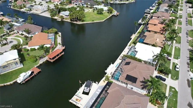 an aerial view of a house lake swimming pool and outdoor seating