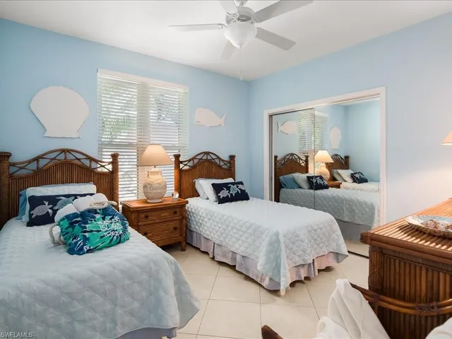 a bedroom with two beds and painting on the wall