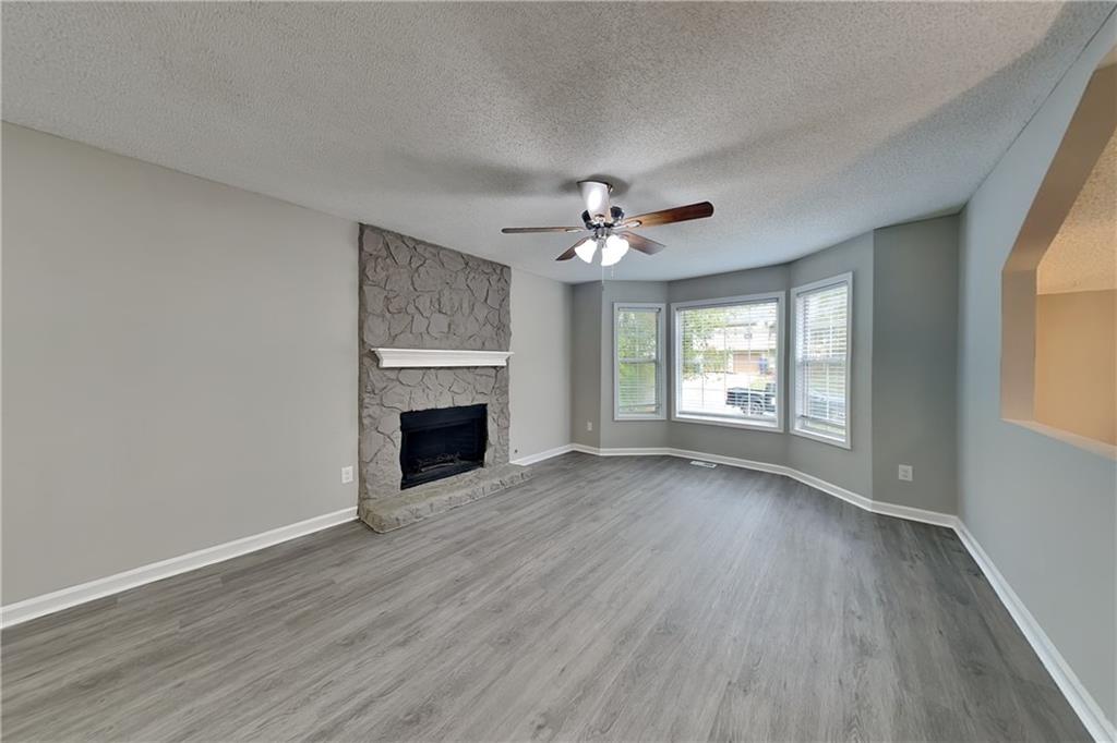 214 Brookside Drive Dallas, GA 30132 - Photo 2 of 20 a view of an empty room with wooden floor fireplace and a window