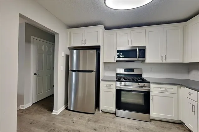 a kitchen with stainless steel appliances a refrigerator stove and microwave