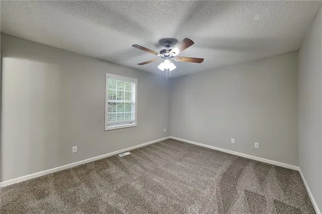 a view of an empty room with a ceiling fan
