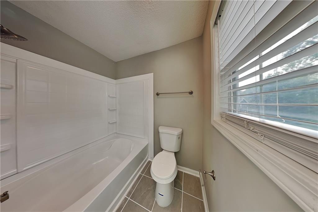 214 Brookside Drive Dallas, GA 30132 - Photo 9 of 20 a bathroom with a toilet and a bathtub
