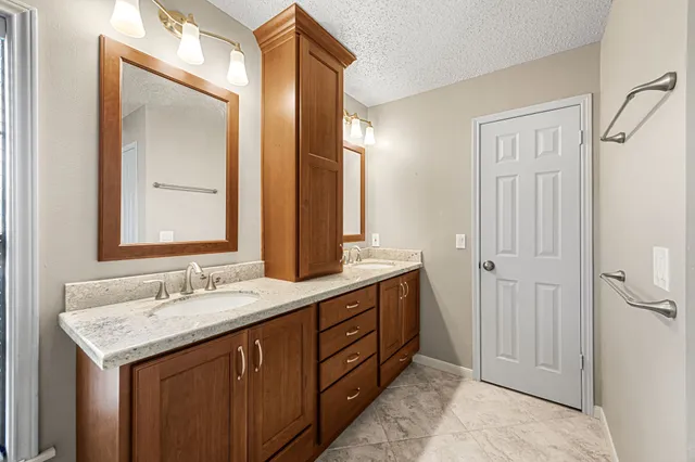 a bathroom with a granite countertop sink and a mirror