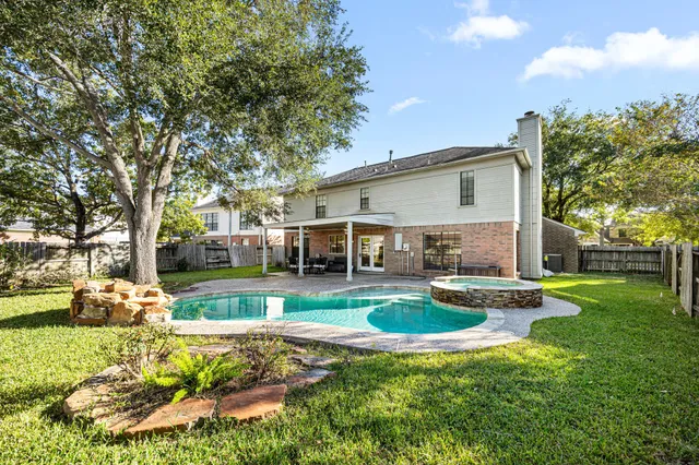 a front view of a house with swimming pool having outdoor seating