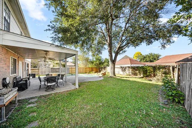 a view of a chair and table in backyard of the house