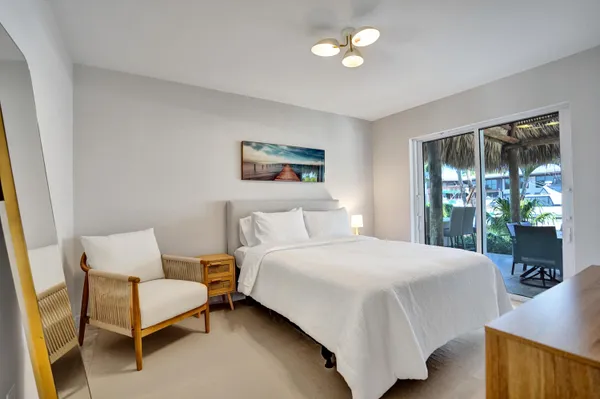 a spacious bedroom with a bed and a painting on the wall