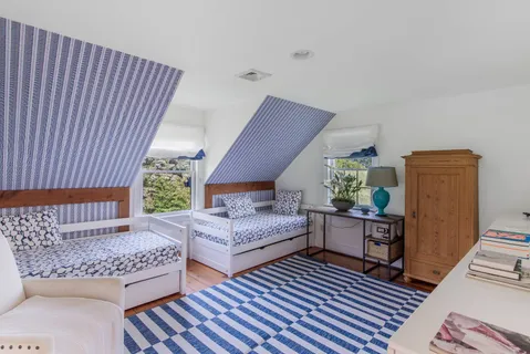 a living room with furniture a bookshelf and a large window