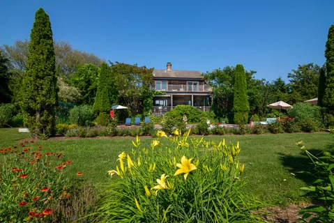a view of a house with a big yard and potted plants